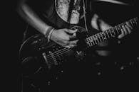 Black and white photo of a guitarist playing during a live performance.